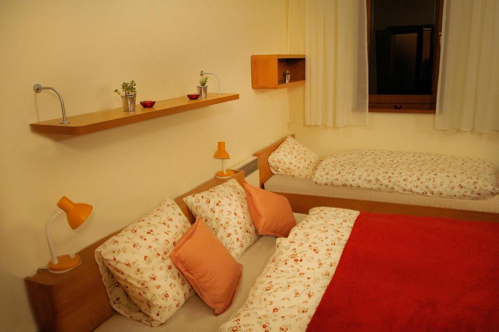 een kamer met 2 bedden en een rode deken bij Apartmán 302 Oščadnica in Oščadnica