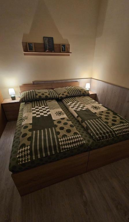 a bed in a bedroom with two lamps on it at Lotti City Apartman in Békéscsaba