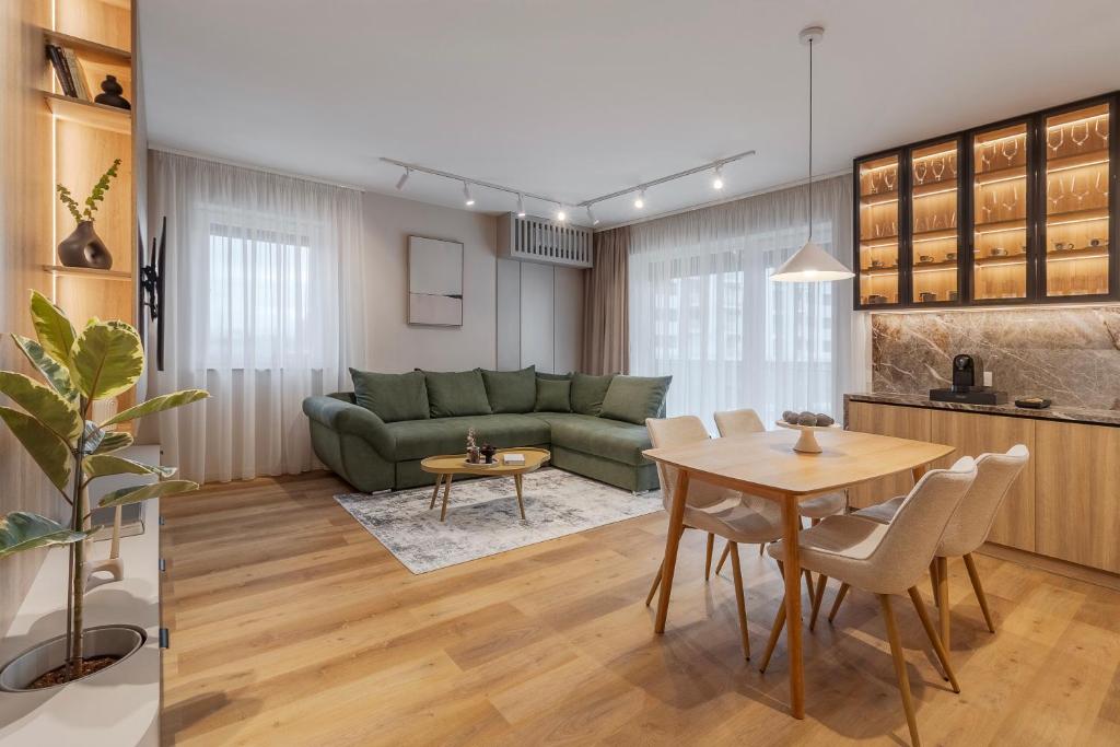 a living room with a green couch and a table at Honey Oak Residence in Oradea