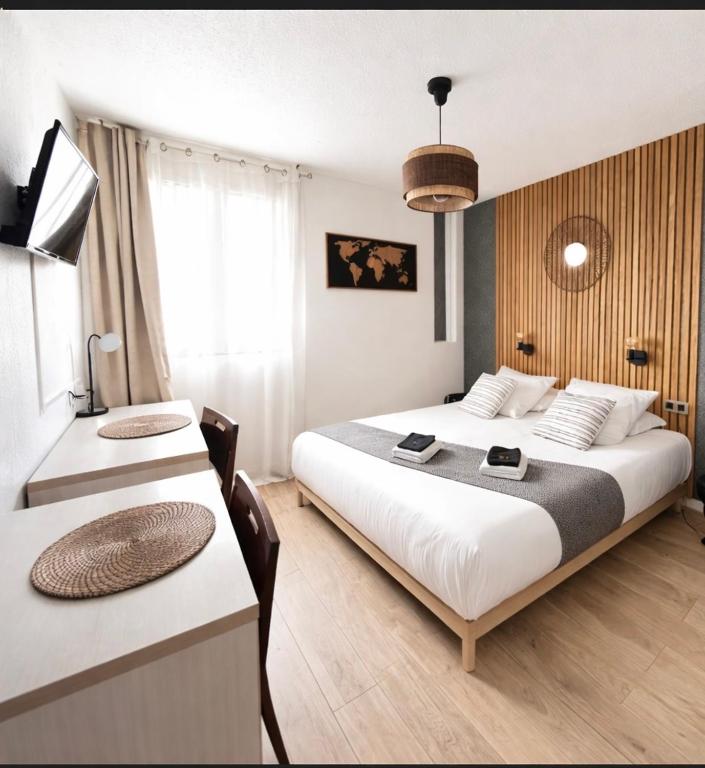 a hotel room with two beds and a table at Appart'Hotel - Gare TGV - Courtine - Confluence - 407 bis in Avignon