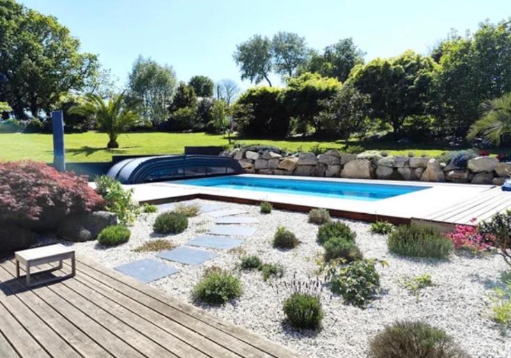a backyard with a swimming pool and a wooden deck at Iroise in Combrit