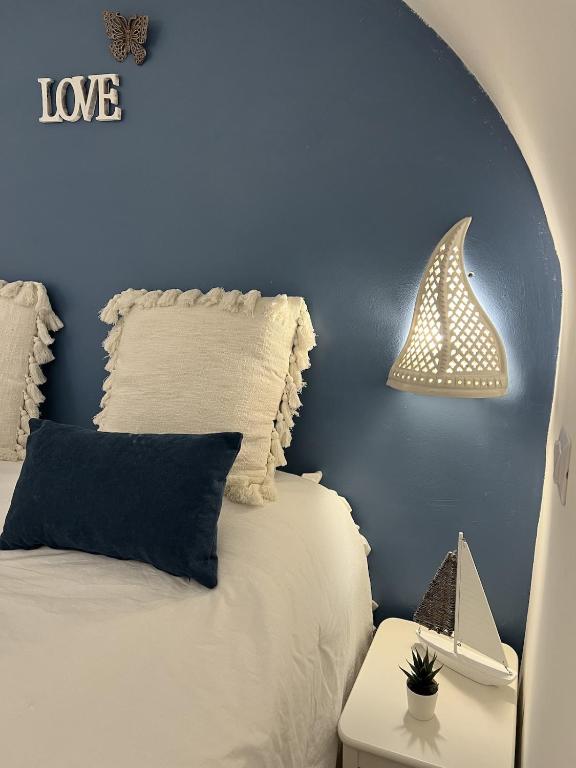 a bedroom with a white bed and a blue wall at Mamy Sweet Loft in Polignano a Mare