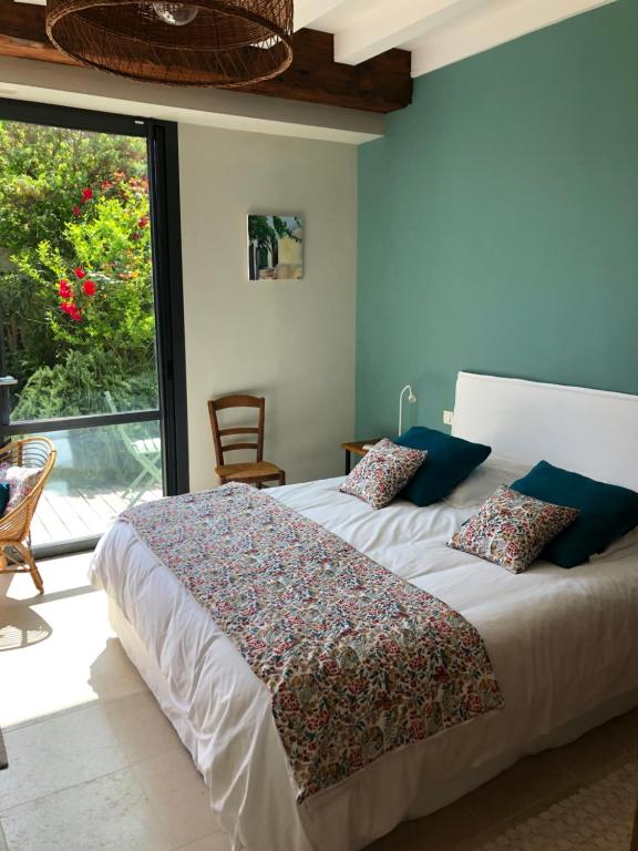 a bedroom with a large bed and a large window at Chai Léopold in Surgères