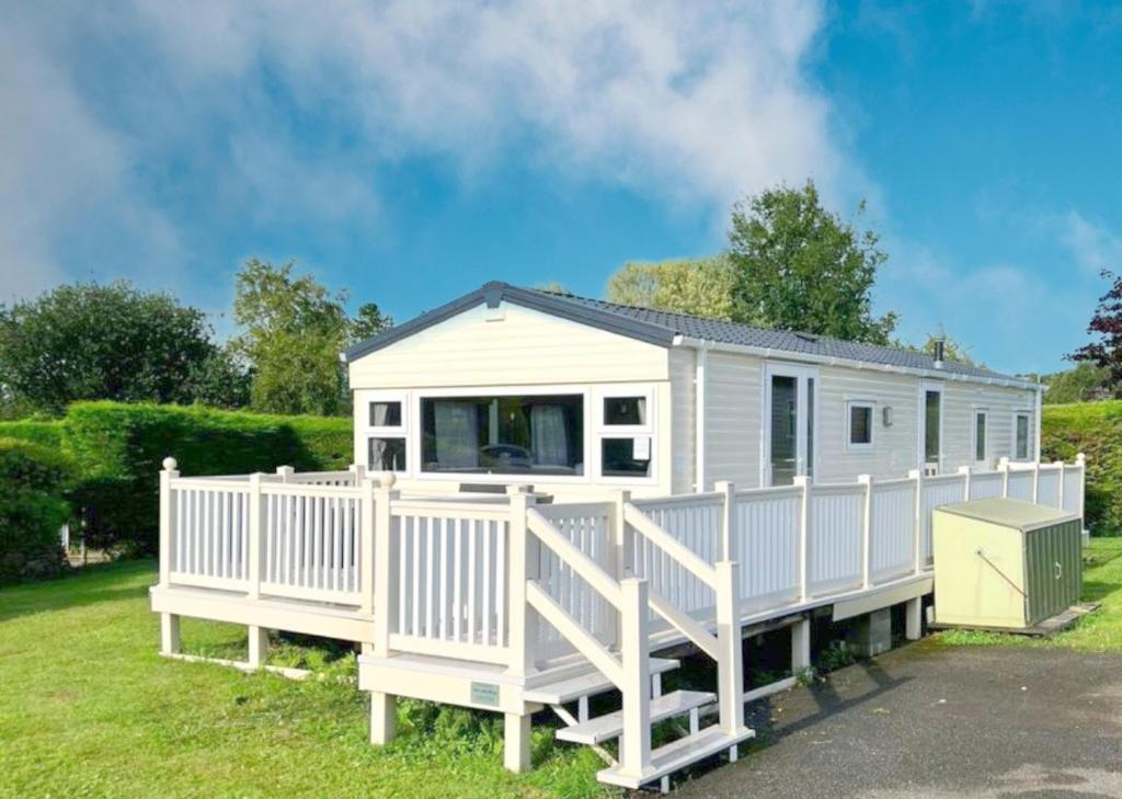 a white tiny house with a white fence at 609 Sycamore Forest in Newquay