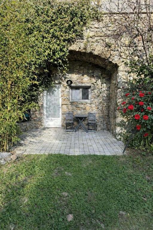 a stone building with a table and two chairs at Tornac, La Madeleine in Tornac