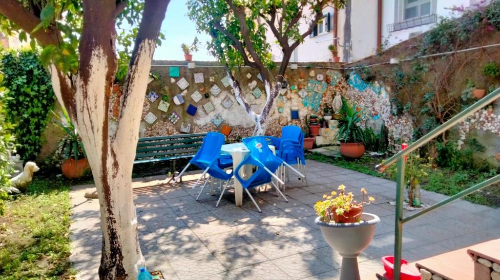 a patio with blue chairs and a table and a wall at La Gemma Amalfitana in Vietri sul Mare