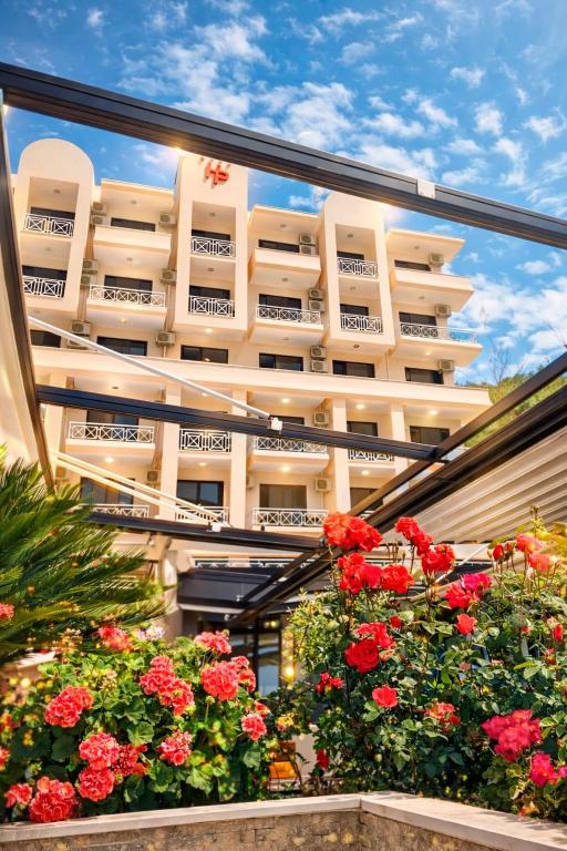 a view of a building with flowers in front of it at Hotel President in Shëngjin