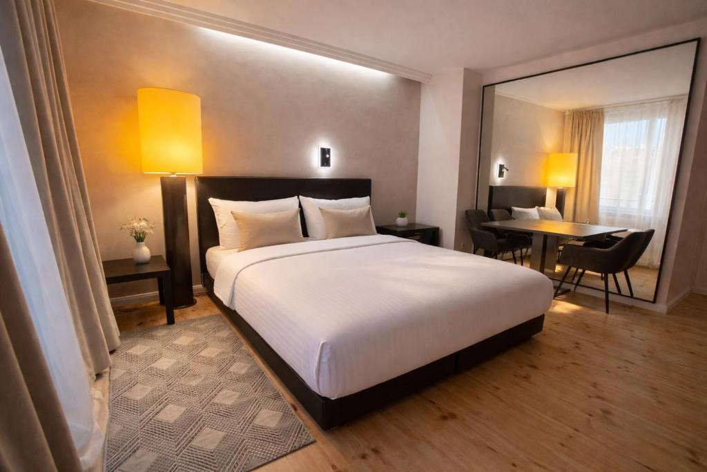una camera d'albergo con un letto, una scrivania e un tavolo di Hotel Adele am Alex a Berlino