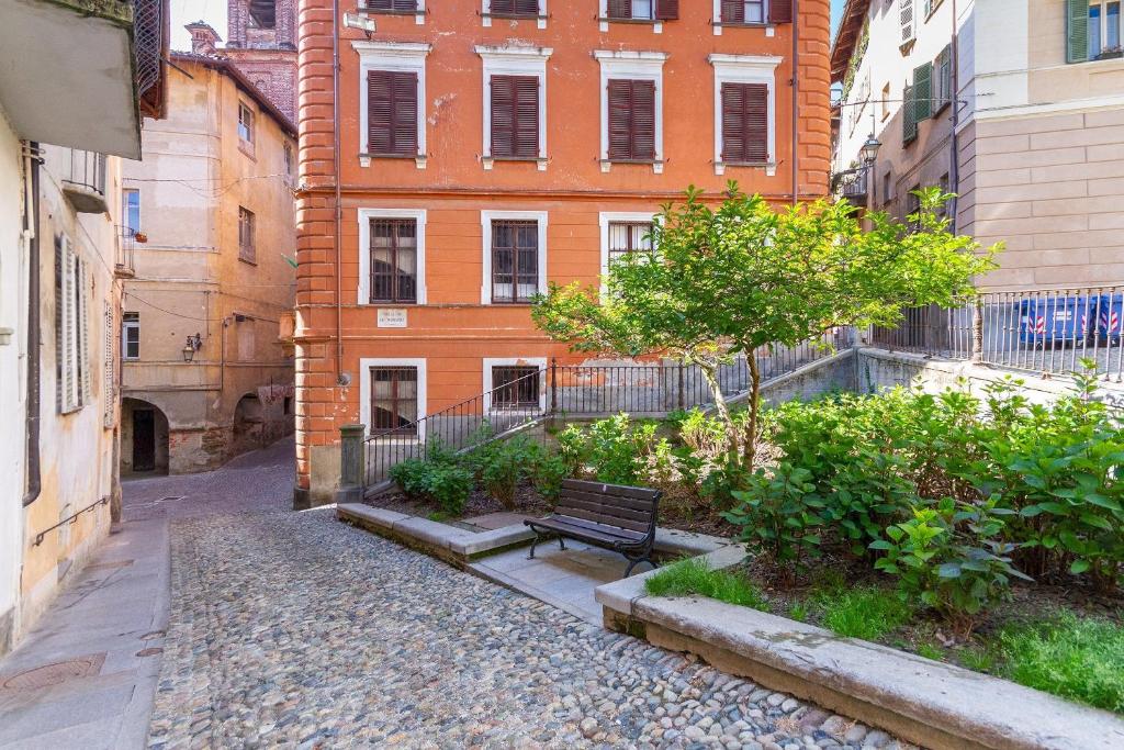an alley with a bench in front of a building at Casa Piazzetta in Saluzzo