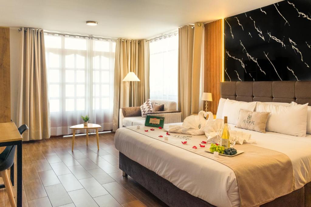 a hotel room with a large bed and a couch at Hotel Anddari in Arequipa