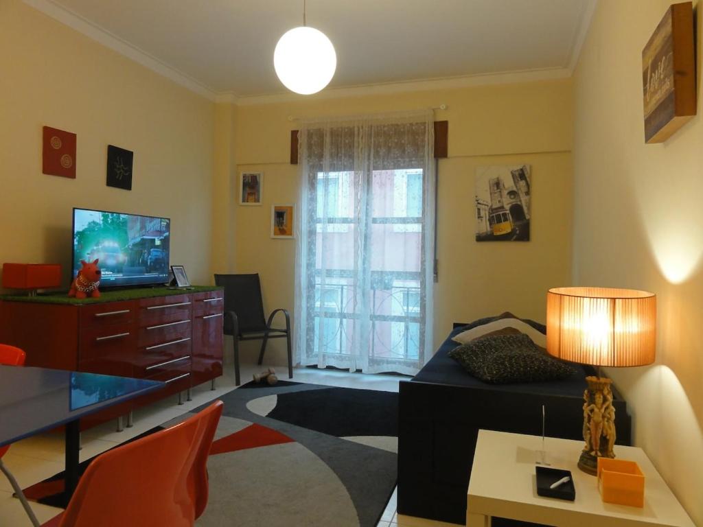 a living room with a couch and a television at Luz de Cacilhas Apt, few steps away from Lisboa! in Almada