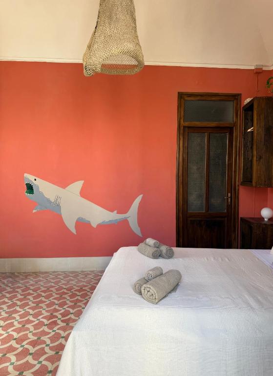 a bedroom with a wall with a fish painted on it at allacasett in Favignana