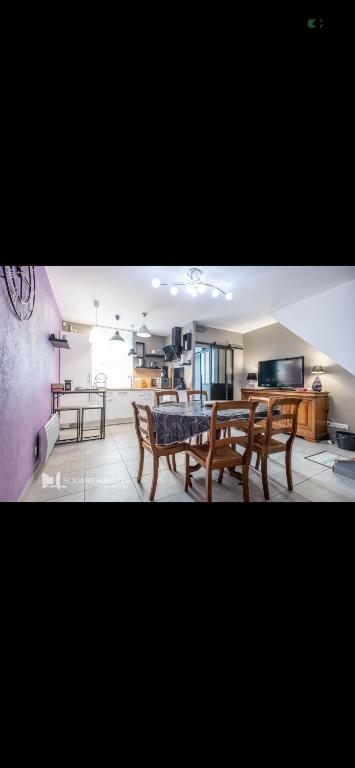 a living room with a table and chairs in it at Chez mimi et Ludo in Saint-Étienne-au-Mont