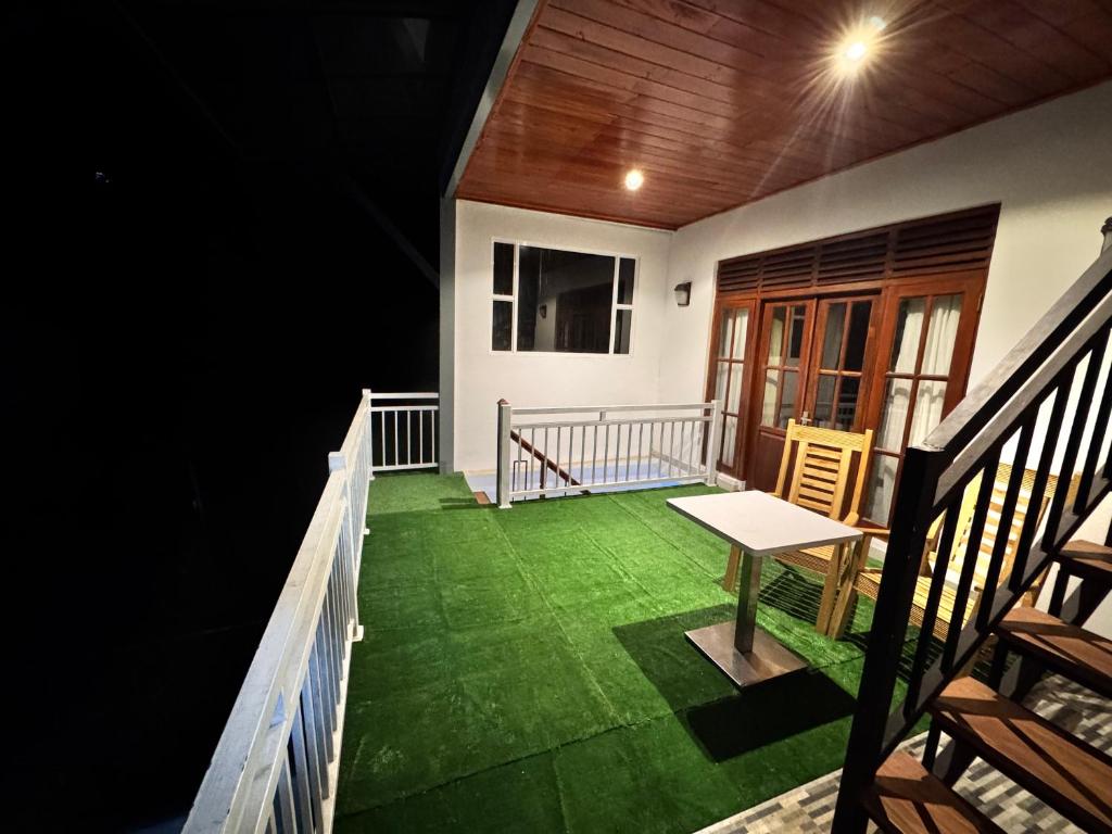 a balcony of a house with a table and chairs at Misty Hills Lakeview Lounge in Kandy