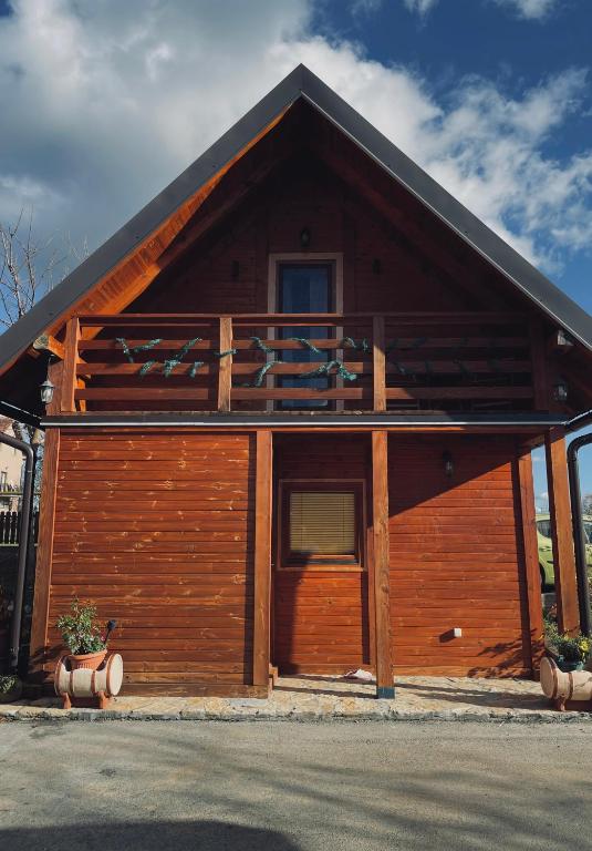 a large wooden cabin with a gambrel roof at Brvnare Nikolić in Zlatibor