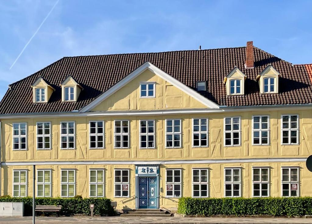 a large yellow building with a red roof at Baroque Palais Timber House Celle in Celle