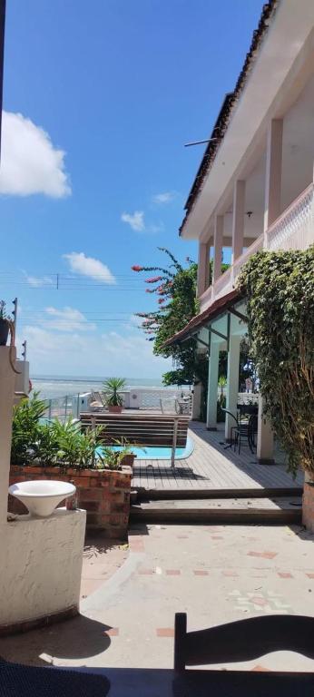 a building with a bench and the ocean in the background at Pousada Casa da Praticagem in Salinópolis