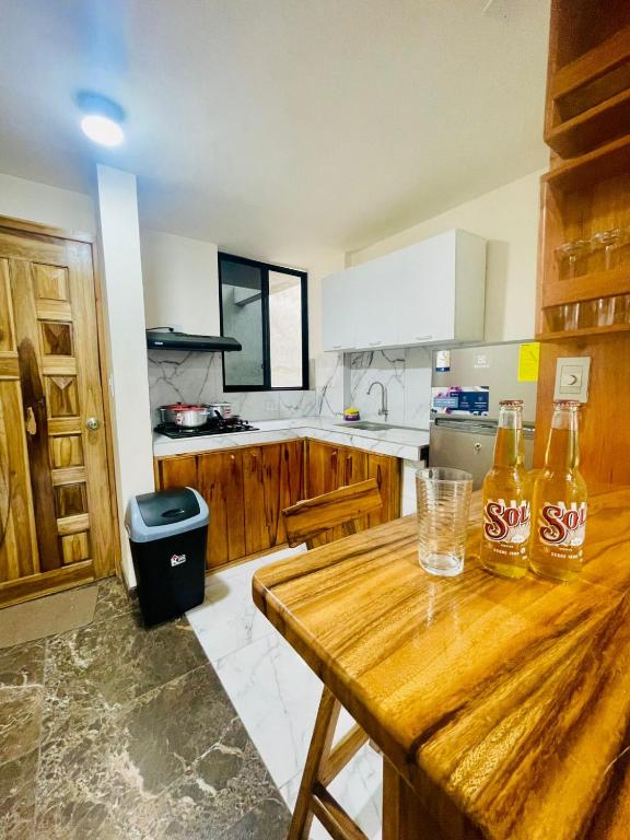 a kitchen with two bottles of soda on a wooden table at Dulce & Guanábana suite House in Canoa