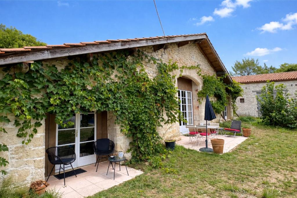 a stone house with ivy on the side of it at Las Coussoulesses in Anthé