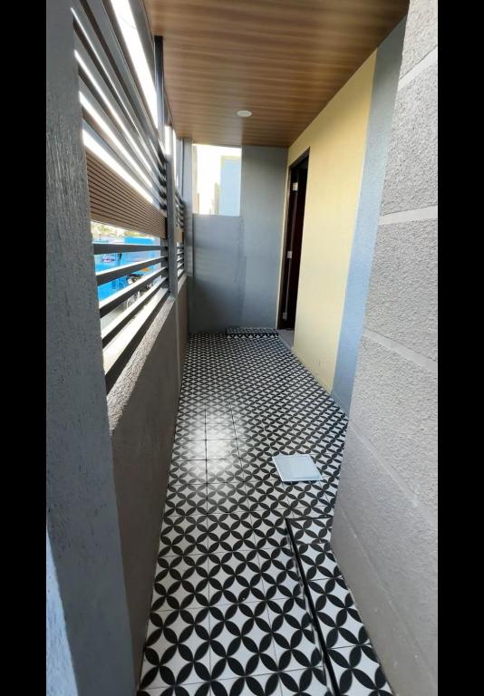 a hallway with a black and white tiled floor at The SOS Pad in Pila