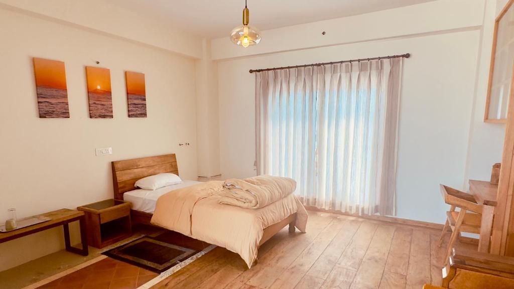 a bedroom with a bed and a large window at Circle of Life in Baudhatinchule