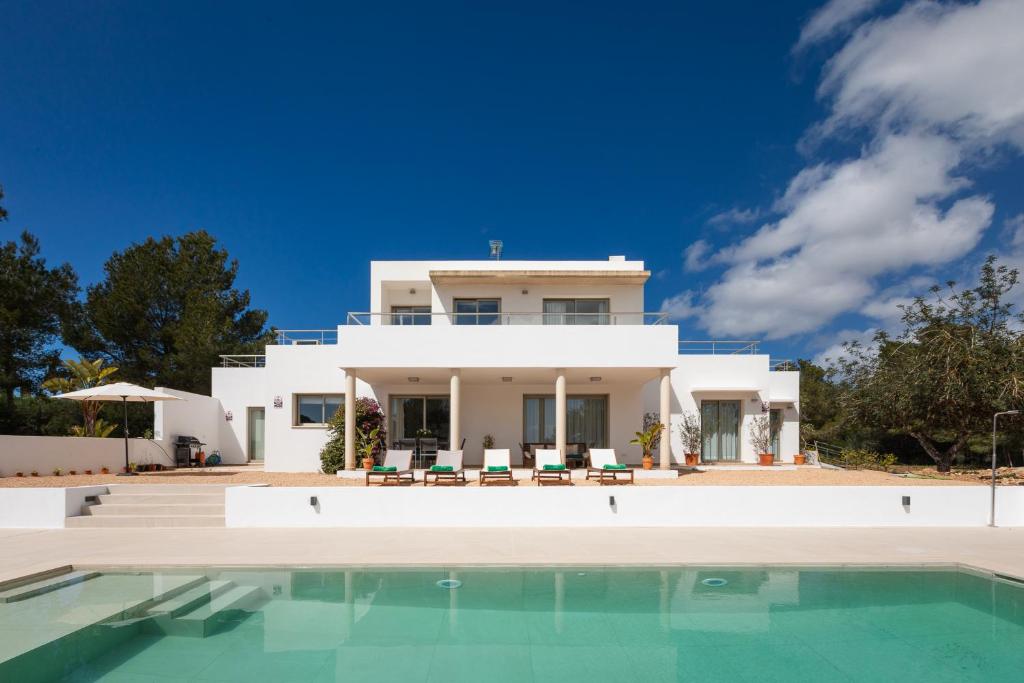 a villa with a swimming pool in front of a house at Villa Es Redo-Spacious & Relax in Sant Josep de sa Talaia