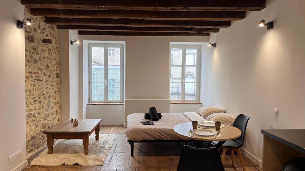 a living room with a bed and a table at Le Chêne Doré in Bellac