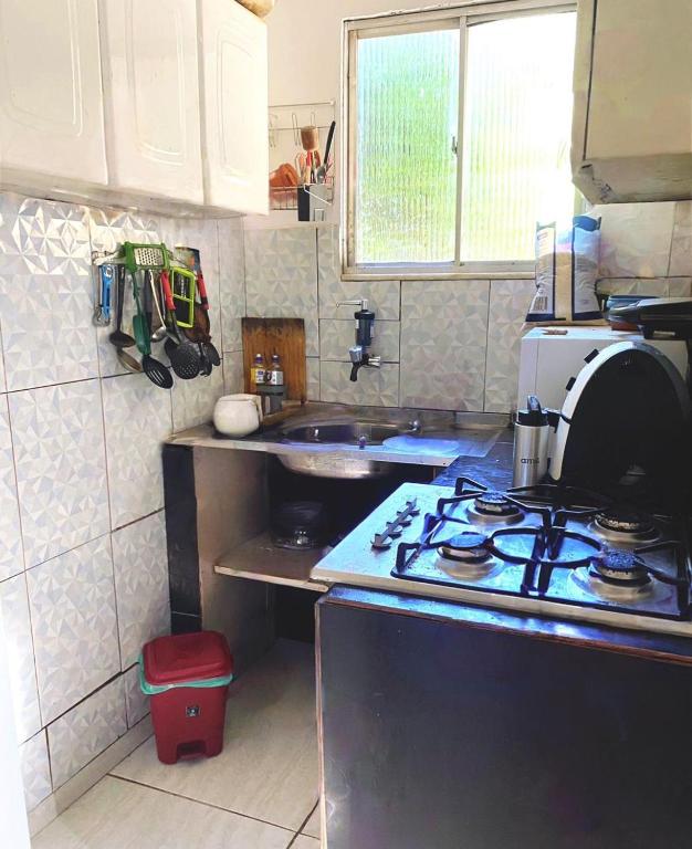 a small kitchen with a stove and a sink at Estúdio Centro 8 minutos da Lapa com Ar e cozinha equipada in Rio de Janeiro