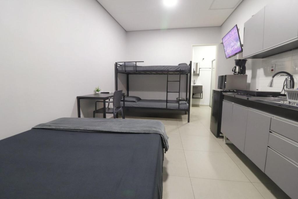 a room with a kitchen with bunk beds in it at Studio IV Jundiaí - Com Ar Condicionado in Jundiaí