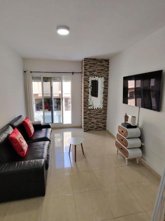 a living room with a black leather couch and a table at Silver House 96 ideal parejas in Arrecife