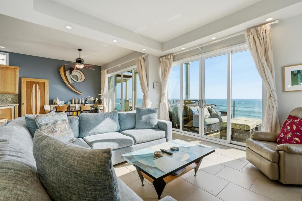 a living room with a couch and a table at Oceanfront 3BR Condo, Balcony, Fire Pit, Shared Beach, Sleeps 6 in Oceanside
