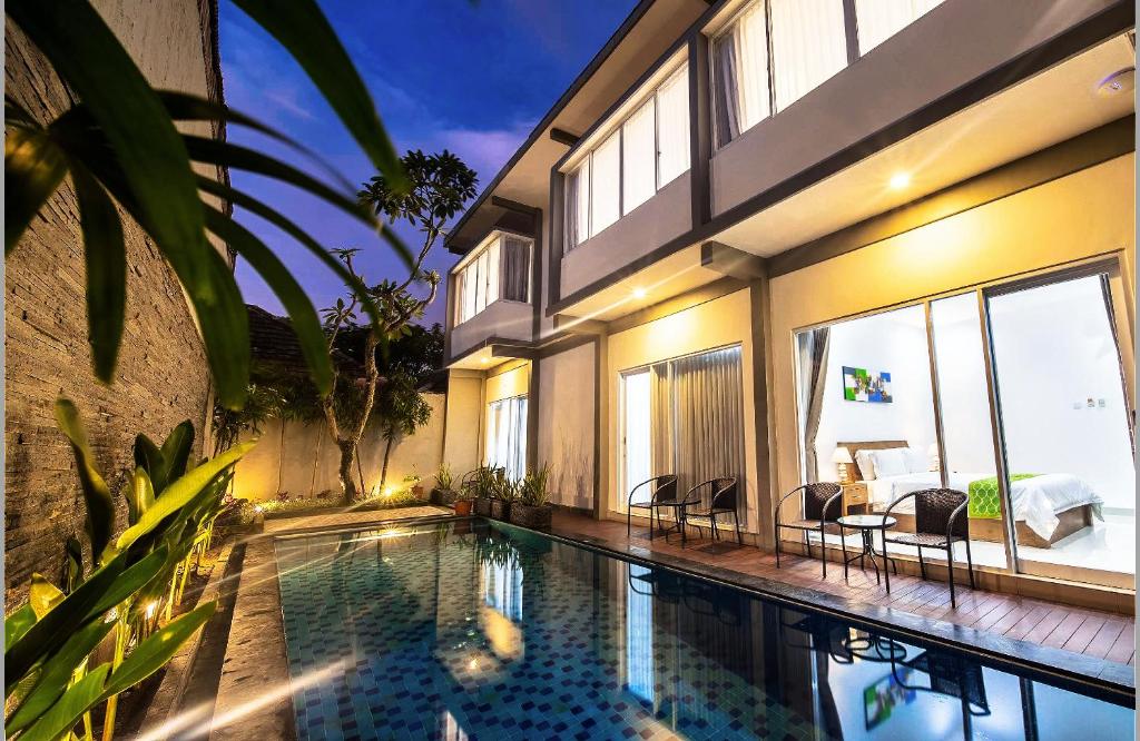 a swimming pool in front of a house at Cozy Guest House Canggu in Kerobokan