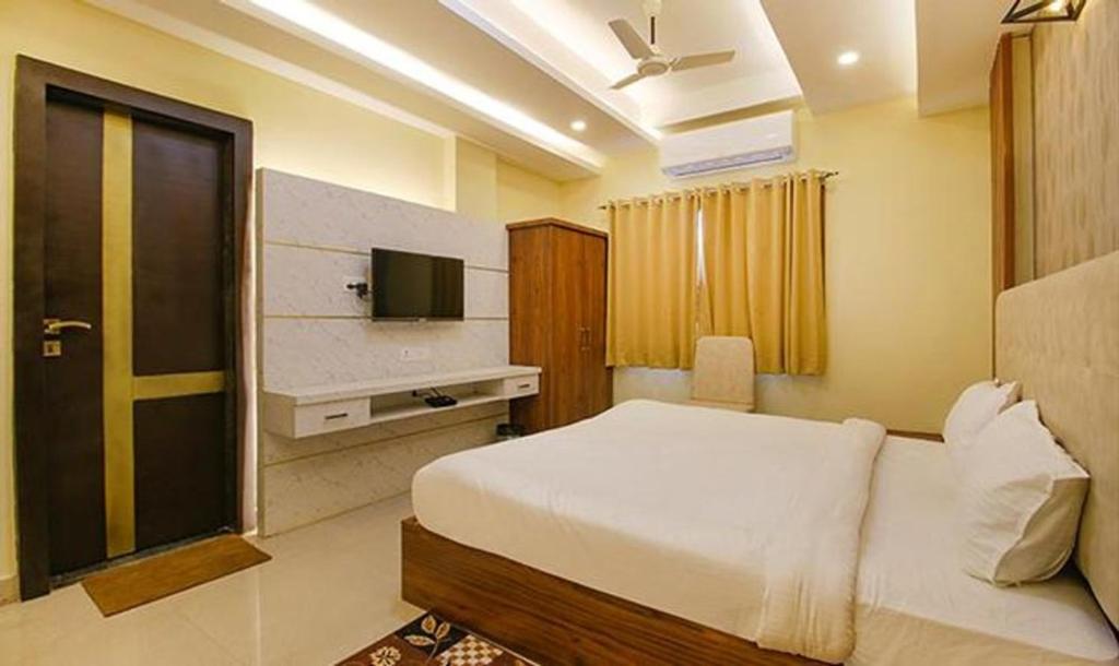 a hotel room with a bed and a television at Hotel Zorba in Bhopal