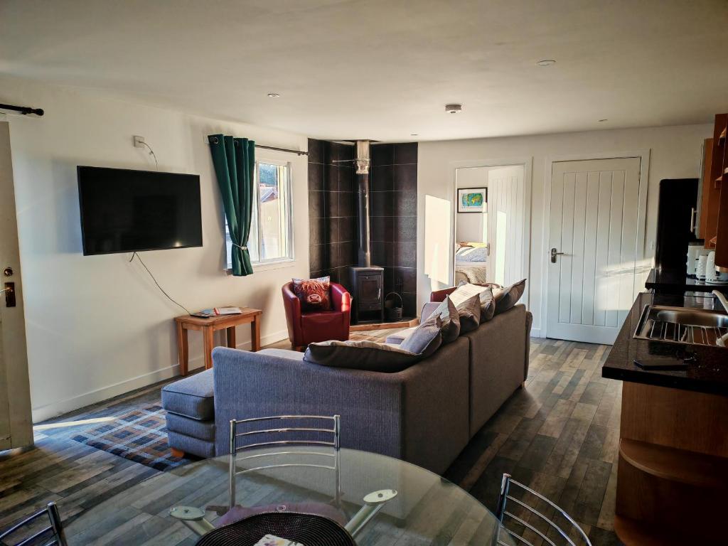 a living room with a couch and a table at Full Pint in Tain