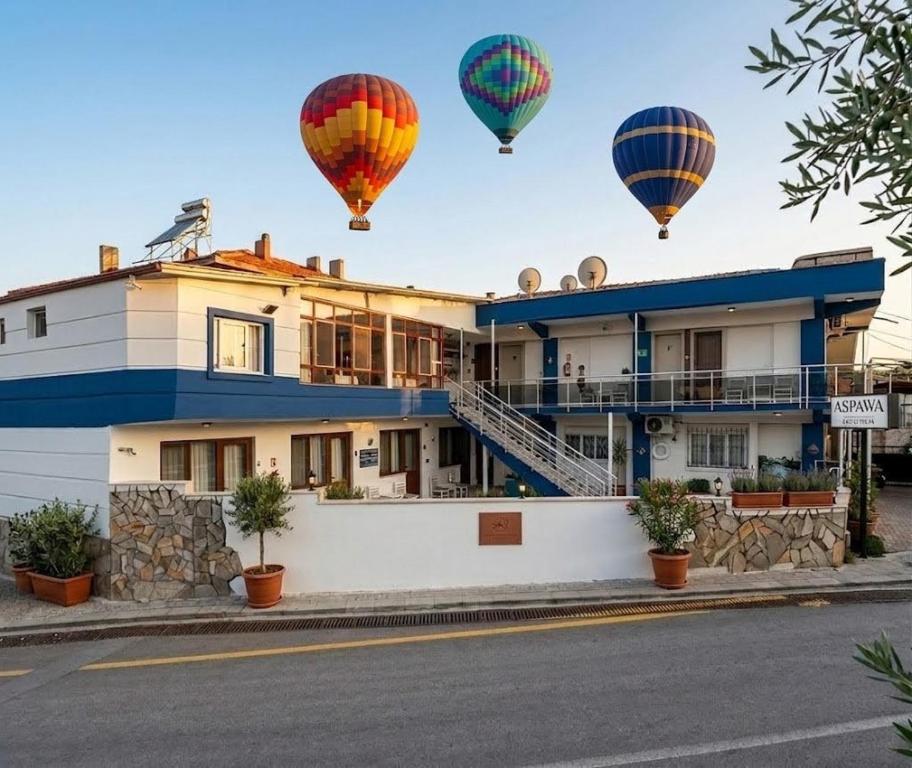 a group of hot air balloons flying over a building at Aspawa Hotel in Pamukkale