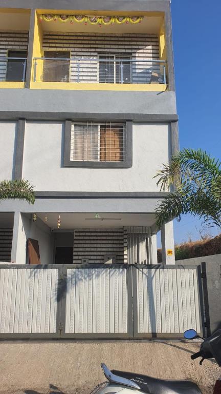 a large house with a white fence in front of it at Umahomestay in Nashik