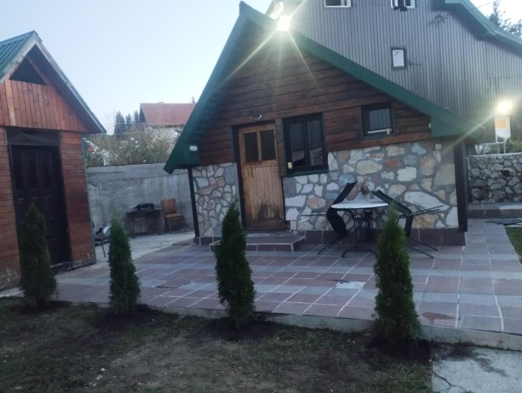 a stone house with a patio in front of it at Vikendica Pejovic in Žabljak
