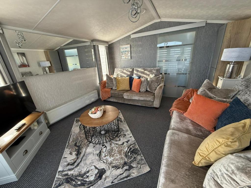 a living room with a couch and a table at Summer Meadows at Sandy Bay in North Seaton