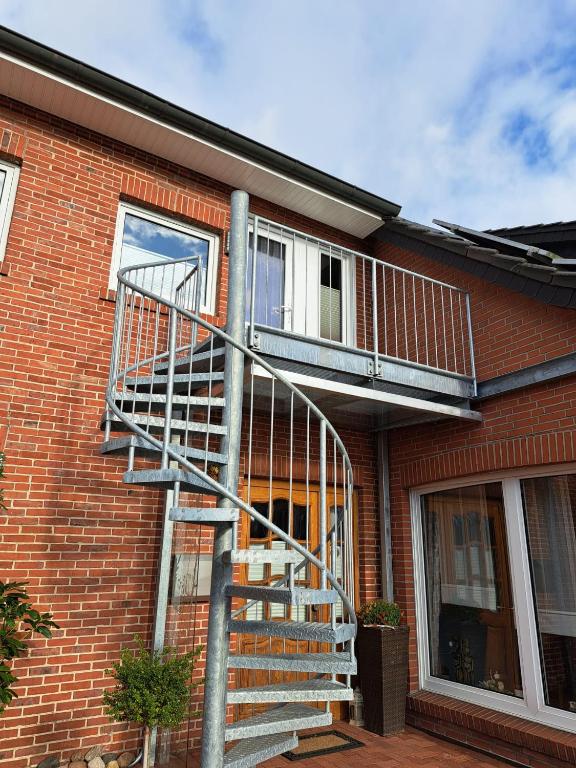 a metal staircase on the side of a brick building at Ferienwohnung Rita in Aschendorf