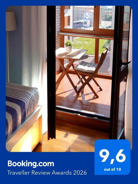 a room with a table and a chair on a balcony at ALMAR, Apartamento en Luanco. in Luanco