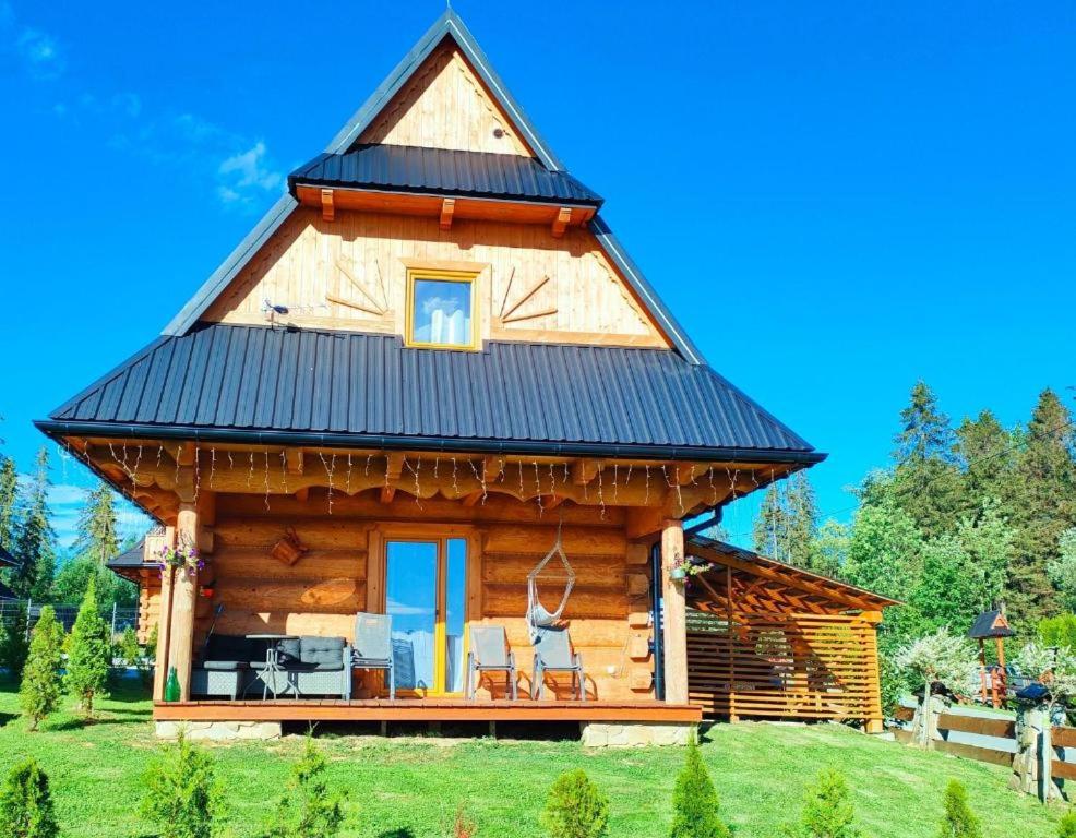 a log cabin with a black roof at Kunatówka domek w Zębie in Ząb