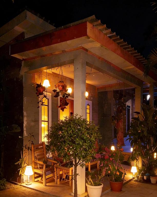 a house with a table and chairs on a patio at night at Eltari Homestay in Tetebatu