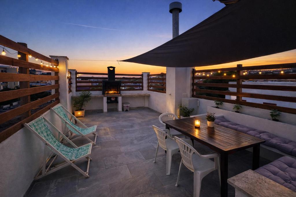 a patio with a table and chairs and a fireplace at Blue House Calafell in Calafell
