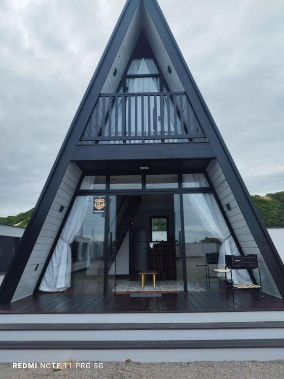 a house with a triangular roof with windows at Dunas beach club in Jaguaruna