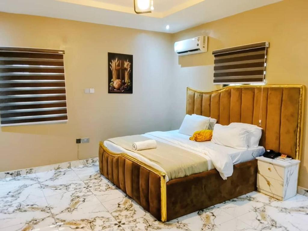 a bedroom with a bed with a wooden headboard at Servy Hotels in Port Harcourt
