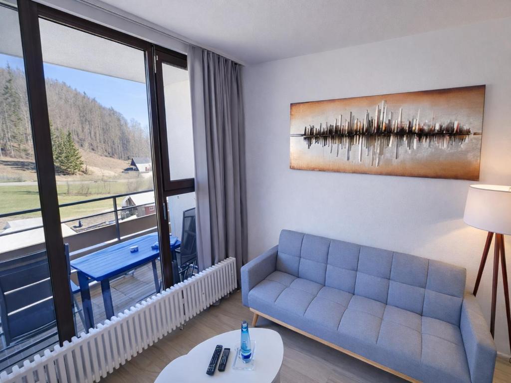 a living room with a couch and a large window at Studio Bernhard mit Pool und Sauna in Freyung