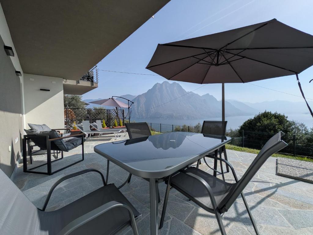 a table and chairs with an umbrella on a patio at Dal Ross 2 in Riva di Solto