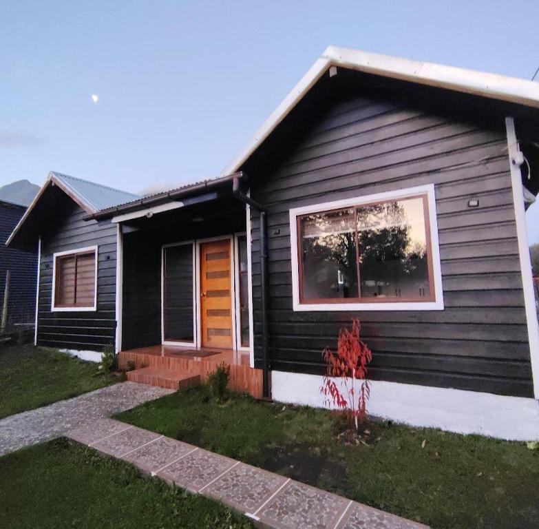 a black house with a window and a door at Casa Azul in Coñaripe