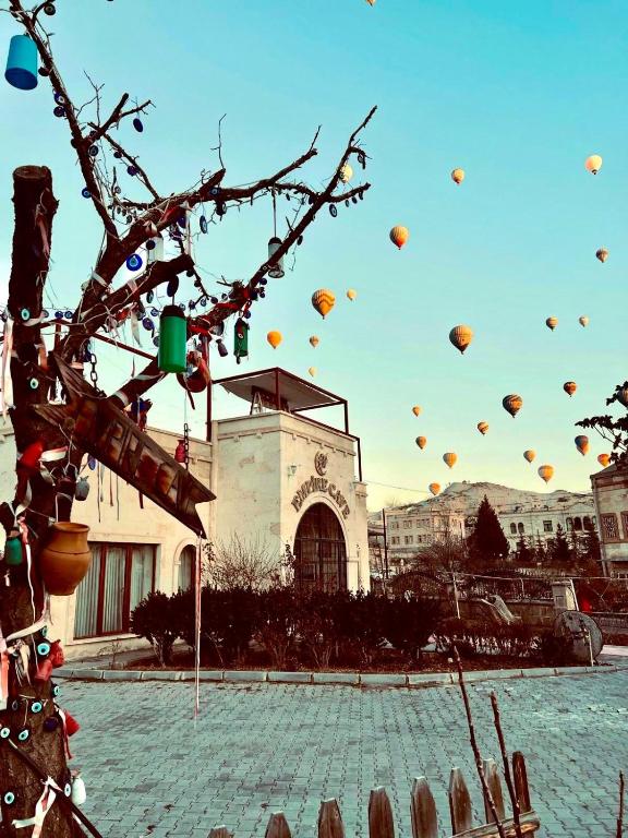 a group of hot air balloons flying in the sky at Empire Cave Cappadocia in Göreme