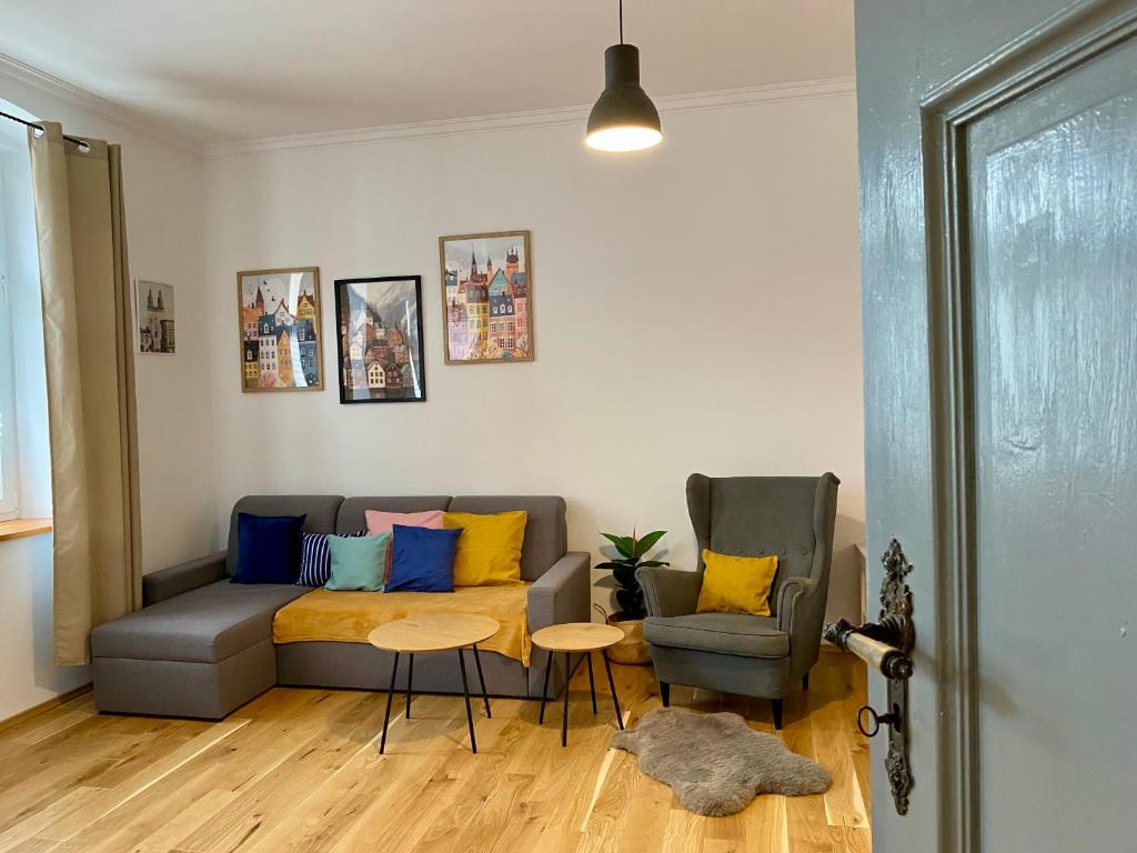 a living room with a couch and a table and chairs at Apartament Pod Tężnią in Głuchołazy